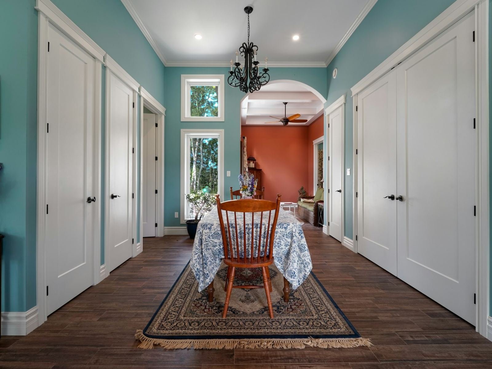 A blue hallway with crisp white doors and trim